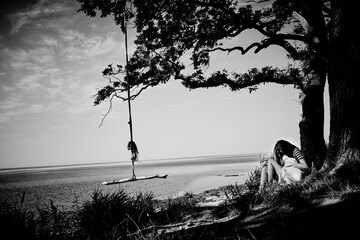 A day at the beach and forest in Denmark. With clouds in the sky, a rope swing and in black and white.