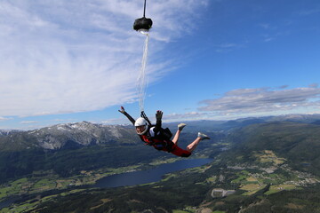 Fototapeta premium Skydivers over snowy mountains in Norway