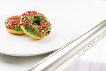 Pączki z nadzieniem i polewą na białym talerzu. Zachęcająca koncepcja na jasnym tle.