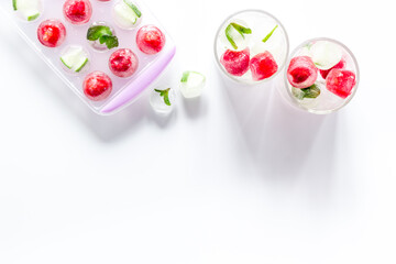 Raspberry and lime in ice cubes on white table top view copy space