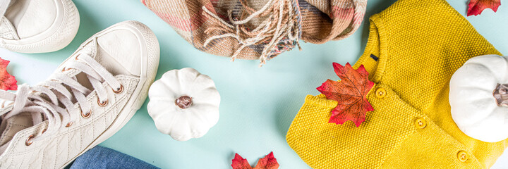 Autumnal clothes set. Cozy casual trendy woman clothing and shoes - jeans, sweater, bad, sneakers. Set of seasonal autumn fashion female clothes, top view copy space