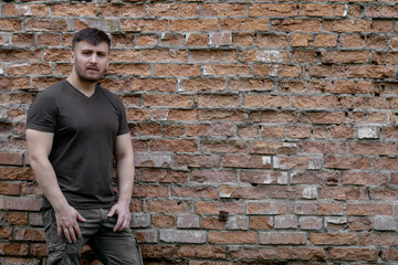 Bearded man on a background of a brick wall.