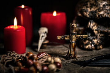 Vodun or voodoo ritual table with candles, puppet and a human skull, black magician - obrazy, fototapety, plakaty
