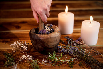 Pulverizing healing herbs and flowers with the mortar, esoteric ingredients for a therapy