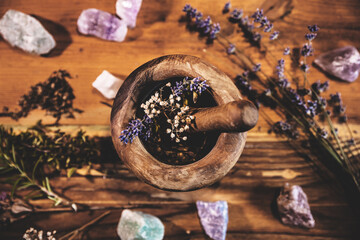 Pulverizing healing herbs and flowers with the mortar, esoteric ingredients for a therapy
