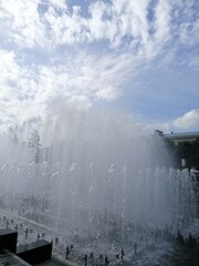 many beautiful fountains behind a granite fence on a Sunny summer day against a blue sky with clouds