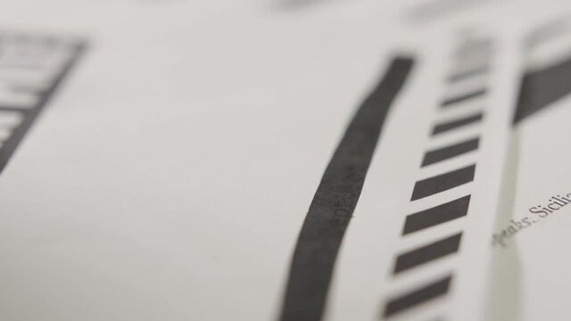 Hand with black marker crossing out sensitive text in a document. Censorship.