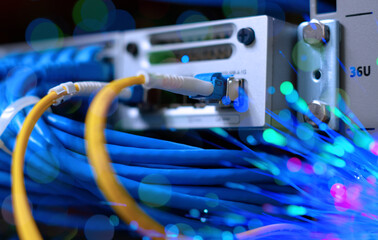 Yellow fiber optic cable with lighting of fiber optics and high speed network router switch in a technology data center room. widescreen - obrazy, fototapety, plakaty
