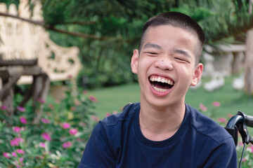 Disabled child on wheelchair is playing, learning and exercise in the outdoor city park like other people,Lifestyle of special child,Life in the education age of children,Happy disability kid concept.