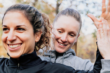 Fototapeta premium A couple of women stretching outdoors in the park