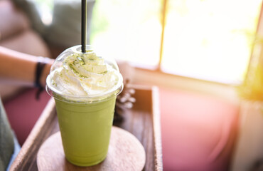 Green tea smoothie - Matcha green tea with milk on plastic glass served in a cafe