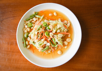 Thai food papaya salad with macadamia nuts on top on white plate Healthy food