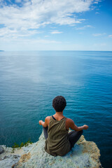 Fototapeta premium person sitting on the rocks
