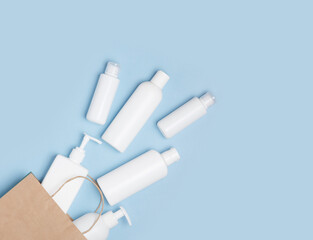 White cosmetic jars are in the shopping bag on a blue background. Purchase of cosmetics and hygiene products, home shopping.