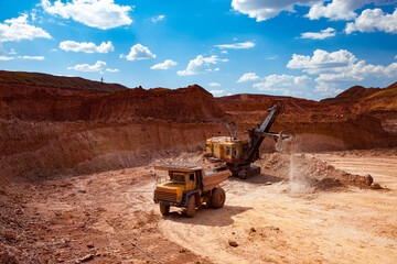 Aluminium ore mining and transporting. Bauxite clay. open-cut mining. Excavator loading ore to dump...