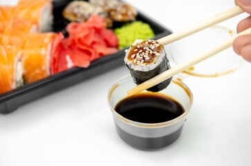 take away sushi in plastic containers, philadelphia rolls and unagi maki, soy sauce, pink ginger, wasabi, sushi delivery concept