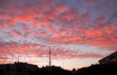 Sunset over the city with beautiful red clouds and silhouette  of tv antenna. Burgas city, Bulgaria