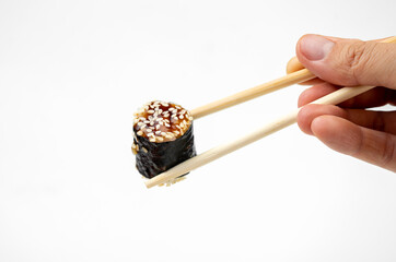 take an unagi maki rolls with bamboo chopsticks on white background, asian food, japanese cuisine