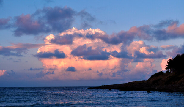 beautiful sunset with orange, pink and blue clouds on the coast of Black Sea. Arapia campig, Bulgaria