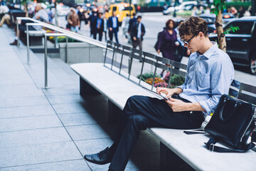 Young man using tablet on bench