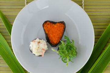 Japanese food put on the white dish on plate the bamboo.