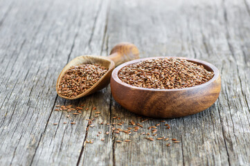 Heap of Flax seeds or linseeds in spoon or bowl on rustic background. Flaxseed concept, dietary fiber background
