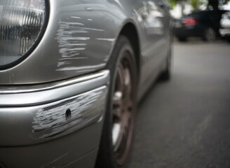 Accidental damage marks on the front bumper of a silver car.