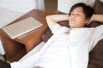 Obraz na płótnie Canvas ソファに寝転ぶ男性