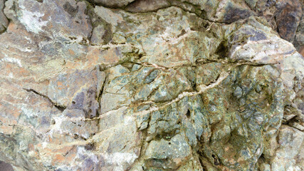 Blue-green texture of natural jasper stone. Jasper stone background with cracks and chips. Boulders for landscaping. Gabbro diabase stone.