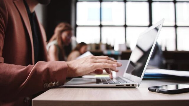 Portrait of man freelancer with laptop working indoors in office, coworking concept.
