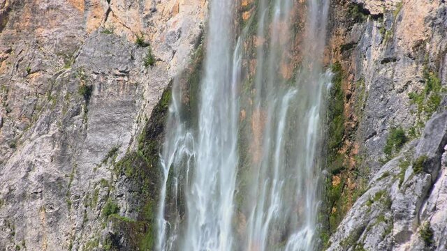 Waterfall Boka in Slovenia. Water gently flowing down the rocks. Moss growing under waterfall. Static, close up, real time