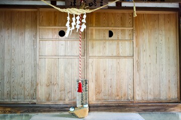 Old wooden door with rope at Japanese shrine in Yamagata.