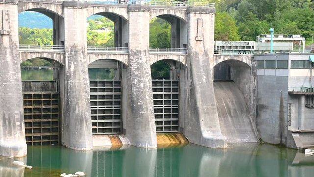 Hydroelectric hydropower power plant on Soča river in Slovenia. Summer dry season. Ecology disaster in pristine nature. Left pan, handheld, wide, 4K