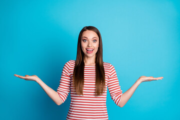 Portrait of shocked positive girl hold hand demonstrate incredible ads promo wear look good clothes isolated over blue color background