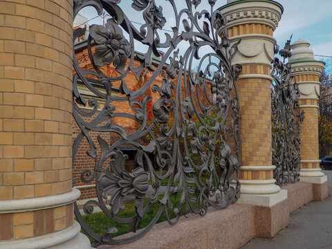 fence with brick columns and wrought iron decorative grating