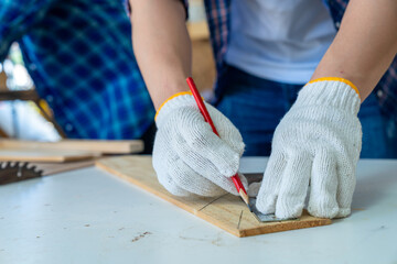 The carpenter is working on the wood cutting table in the wooden factory. Worker or Professional constructor repair workshop in wood working.