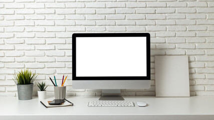 Mockup blank screen computer on a wooden desk. desktop empty white screen, with workspace and office supplies on table