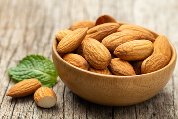 Almonds in Wooden bowl on old wooden table