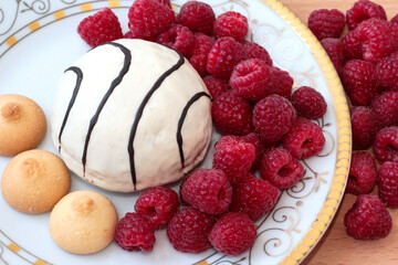 Pastry with raspberries on a white plate. Ripe berries.