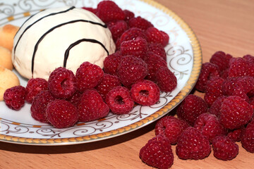 Pastry with raspberries on a white plate. Ripe berries.
