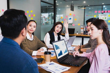 Focus on young beautiful asian woman having question in group brainstorm meeting in office.Businesspeople discussing with paperwork for business plan,Corporate of modern colleague