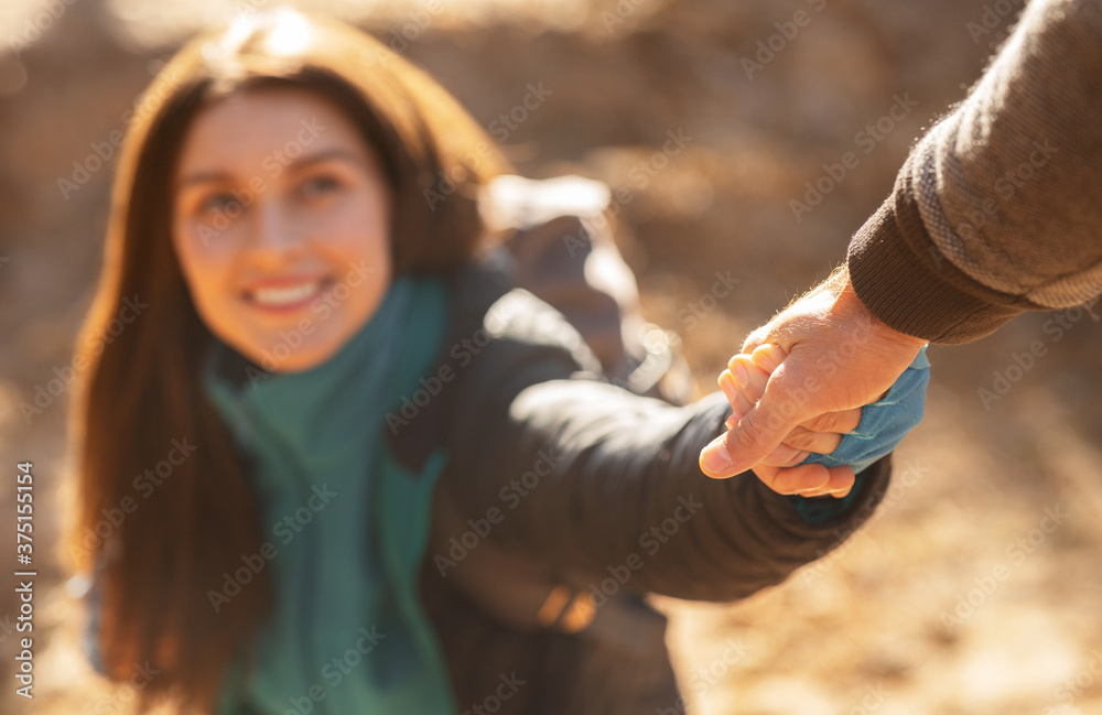 Wall mural Happy young woman outstretching hand to unrecognizable man