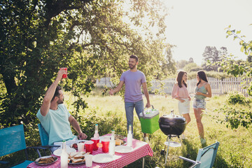 Portrait of four people nice attractive best cheerful friends group spending weekend pastime sunny day bbq preparing lunch meal feast occasion sunny day outdoor