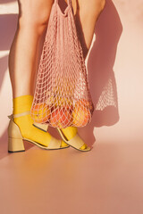 Woman in sandals and yellow socks holding shopping bag