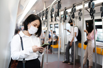 Asian woman wearing a mask traveling by subway while there is an outbreak of COVID-19 in the country.