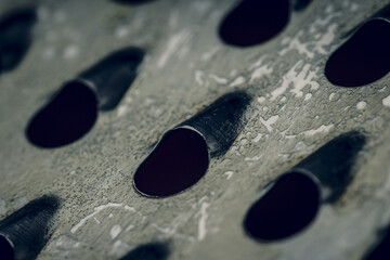 Some fragment of a metal chrome grater close-up. Texture of blades. Soft focus .