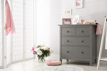 Grey chest of drawers in stylish room interior
