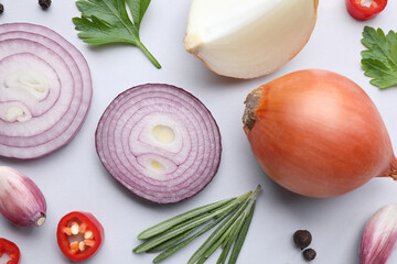 Flat lay composition with cut onion and spices on light background