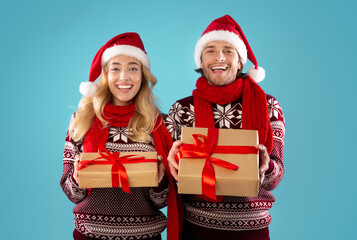 Christmas shopping. Portrait of happy couple with Xmas gifts over blue background