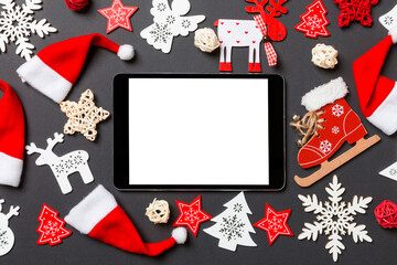Top view of digital tablet. New Year decorations on black background. Merry Christmas concept